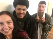 Three people taking a group selfie at an indoor gathering.