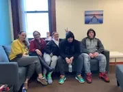 Five participants sharing a relaxed moment on a couch.