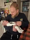 An adult holding a newborn in a home.