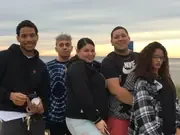 Five participants gathered outdoors beneath the evening sky.
