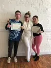 Three people celebrating with certificates.