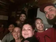 A group smiling together inside a wooden cabin.