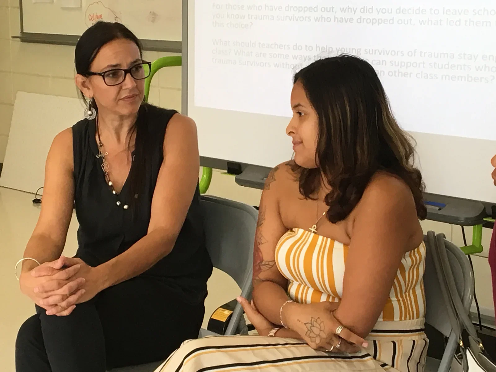 Two participants in conversation during a presentation.