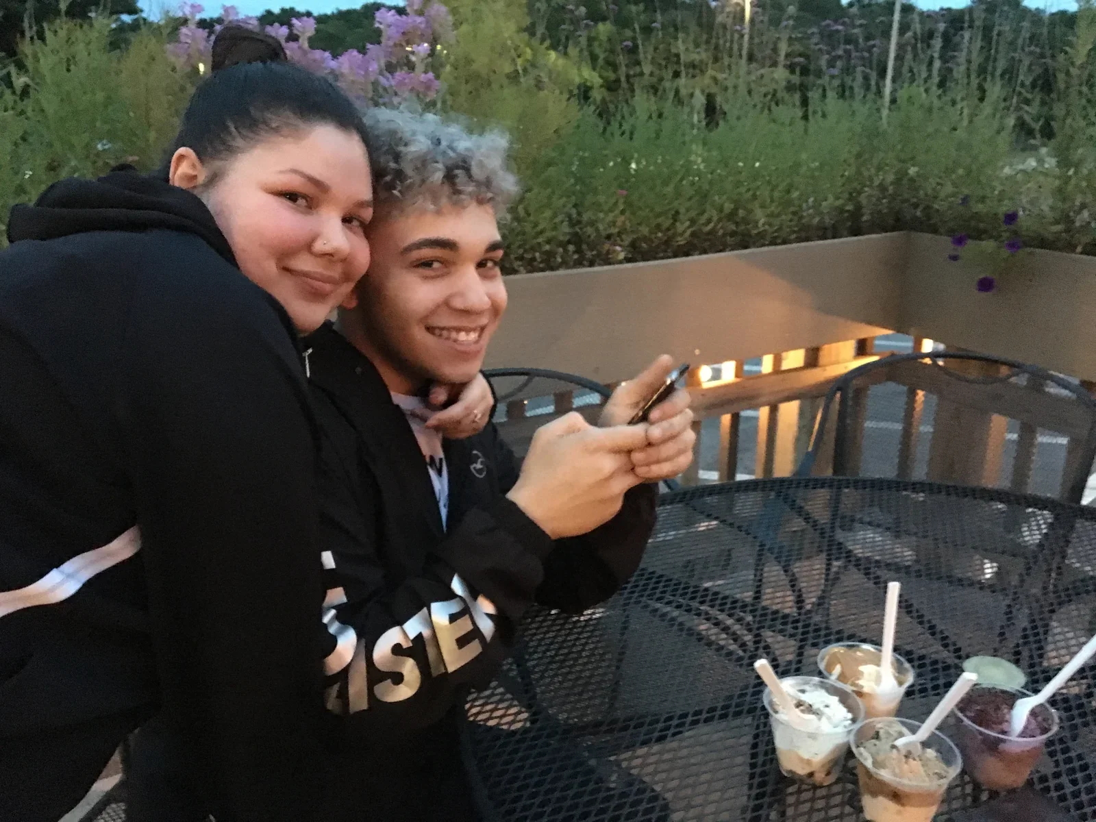 Two participants smiling together on a deck outdoors.