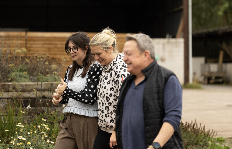 Three retreat guests walking and laughing together outside