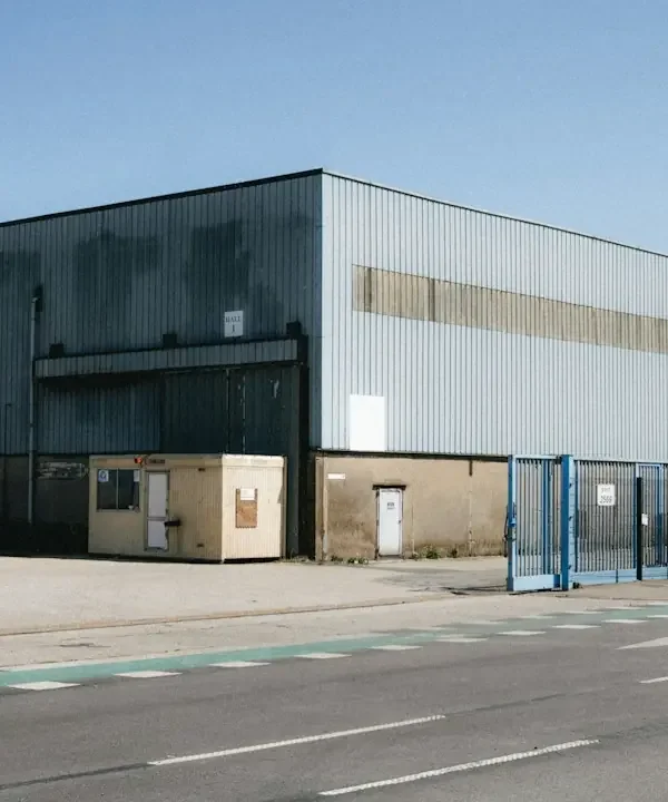 Metal-sided industrial warehouse beside a street
