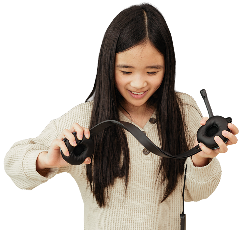 Young girl holding durable over-ear headphones against a white background