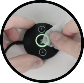 Hand wiping the in-line volume and mute controls on a call center headset cable with an alcohol wipe