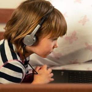 Child wearing headphones and studying