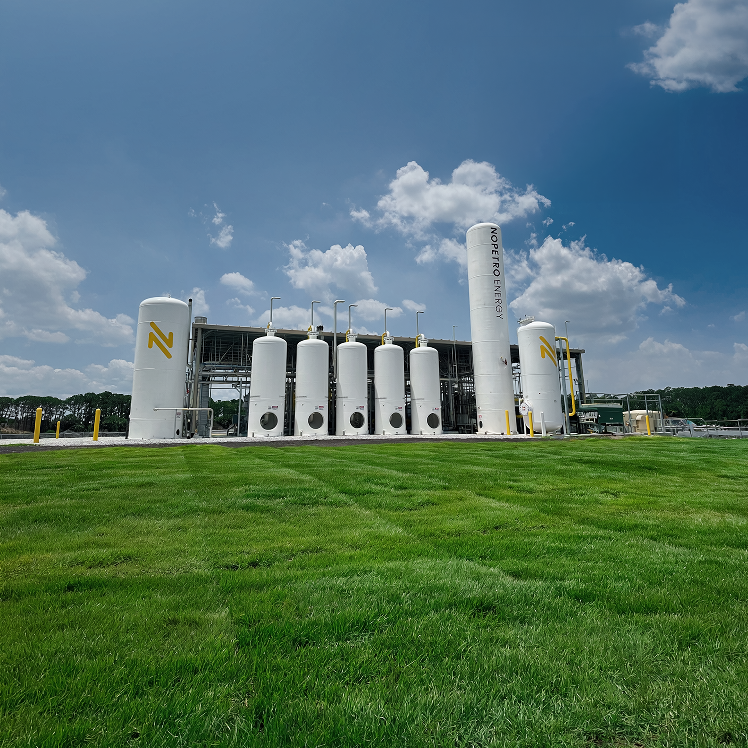 Several white energy pylons in a grassy field.