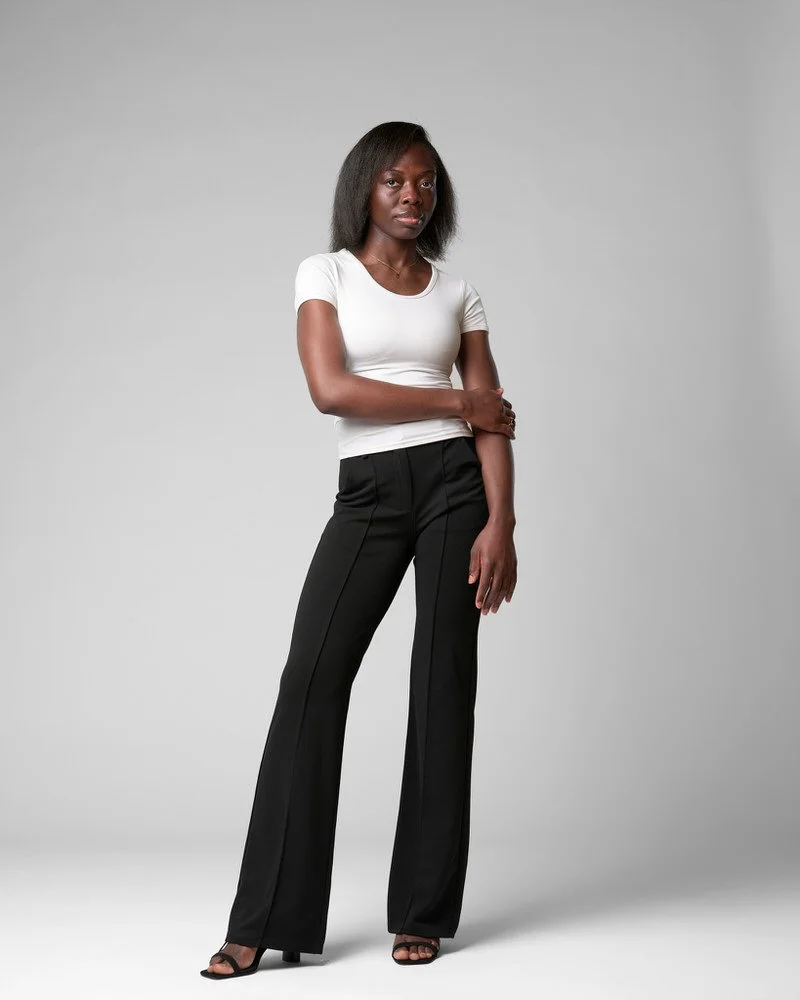 Full-length image of a model in a white tee and black trousers