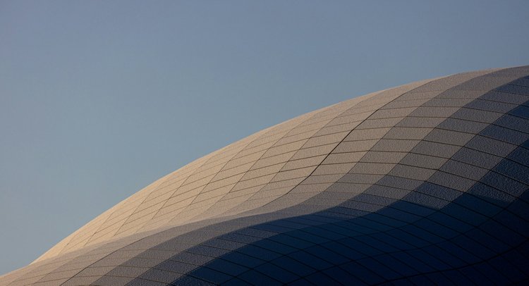 Close-up view of a modern architectural dome with curved metallic panels reflecting light, symbolizing innovation and forward-looking technology.