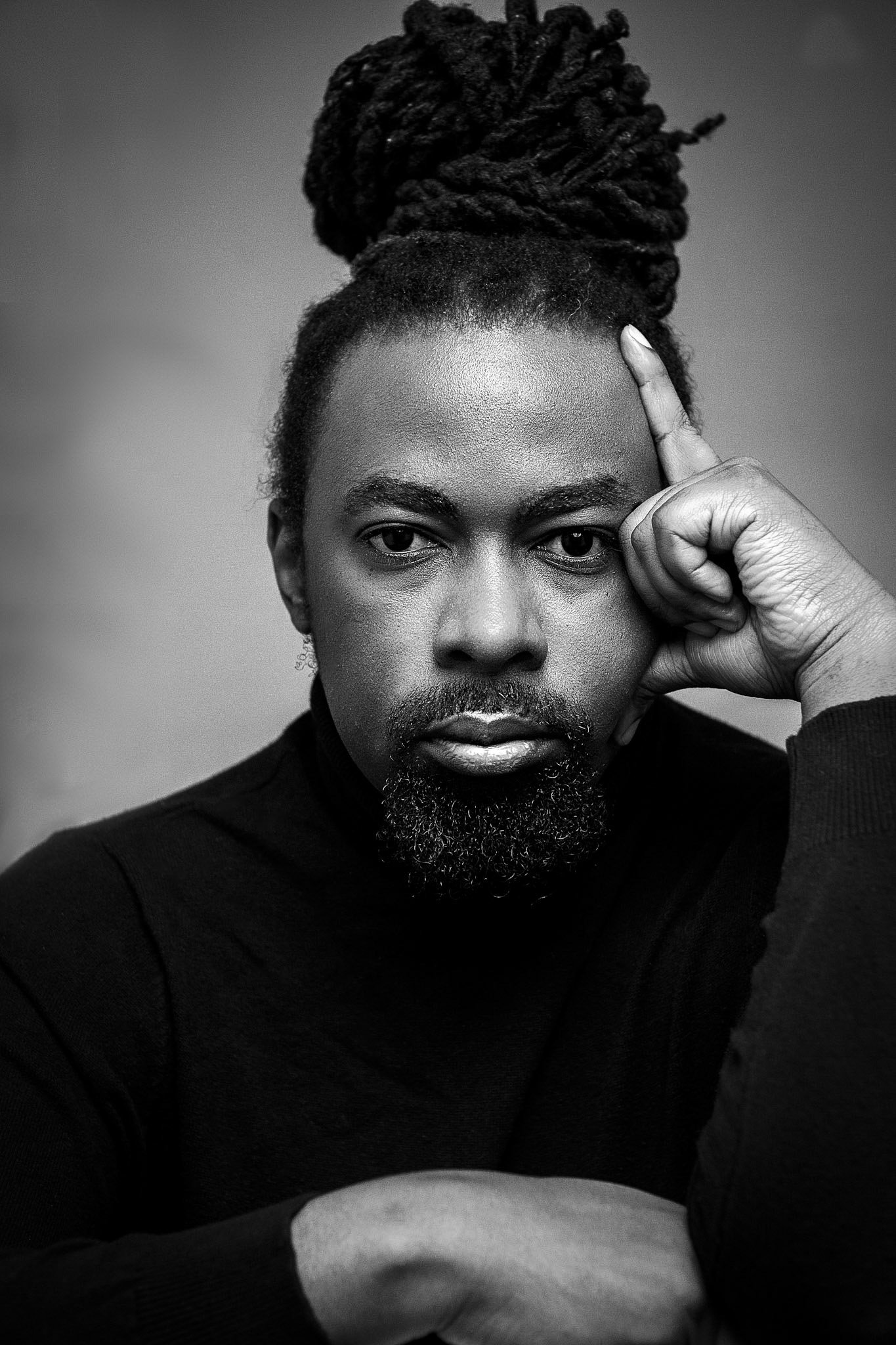 Archive black-and-white portrait of Brayo with his locs tied up