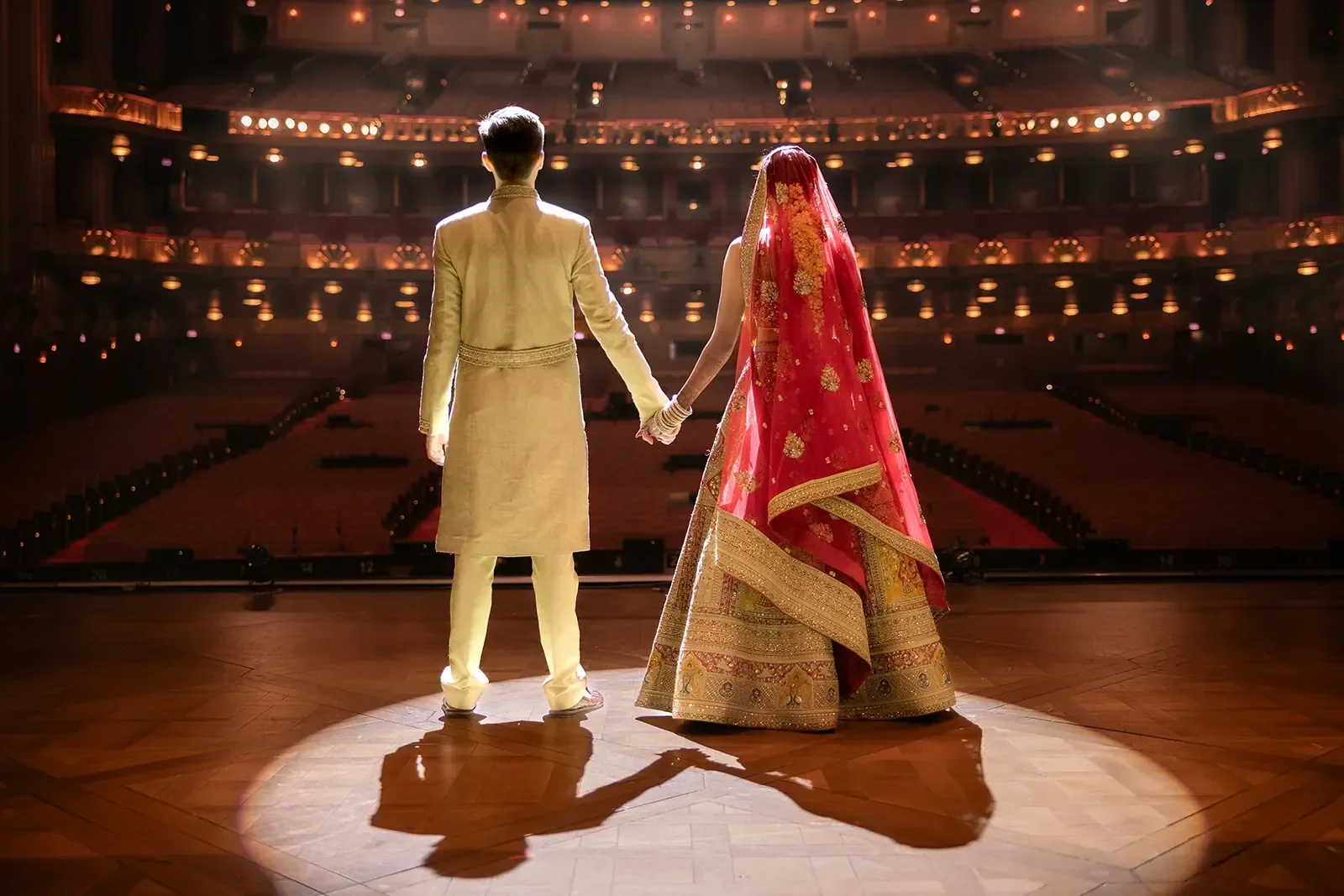 Lyric Opera Chicago wedding photography - Couple in traditional dress holding hands under dramatic lighting