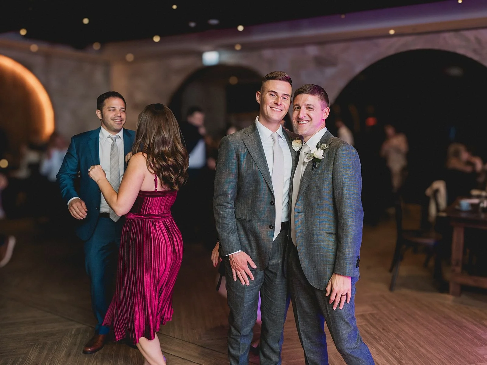 Two grooms portrait with glowing arch