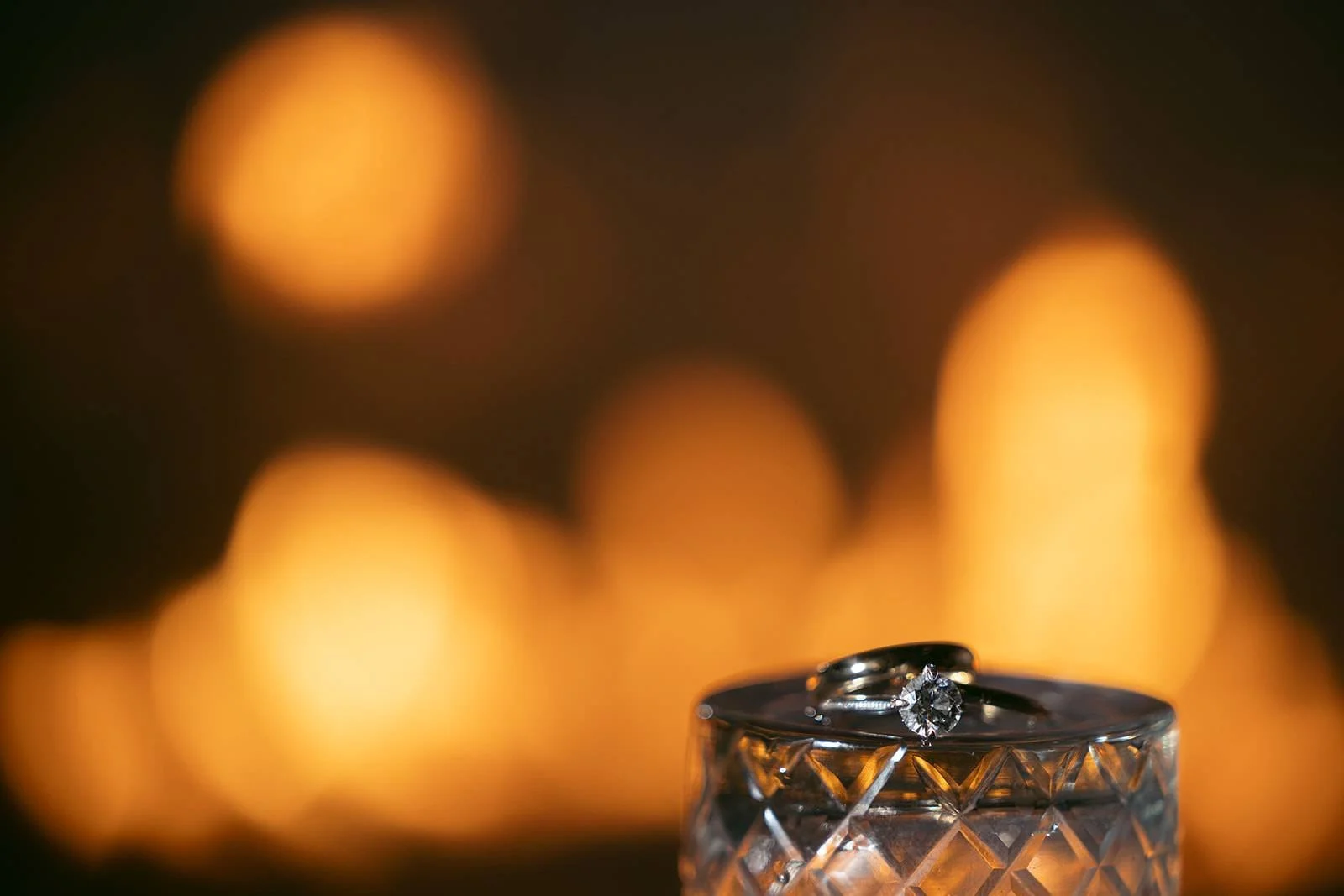 Wedding rings with candlelit bokeh at Chicago Winery