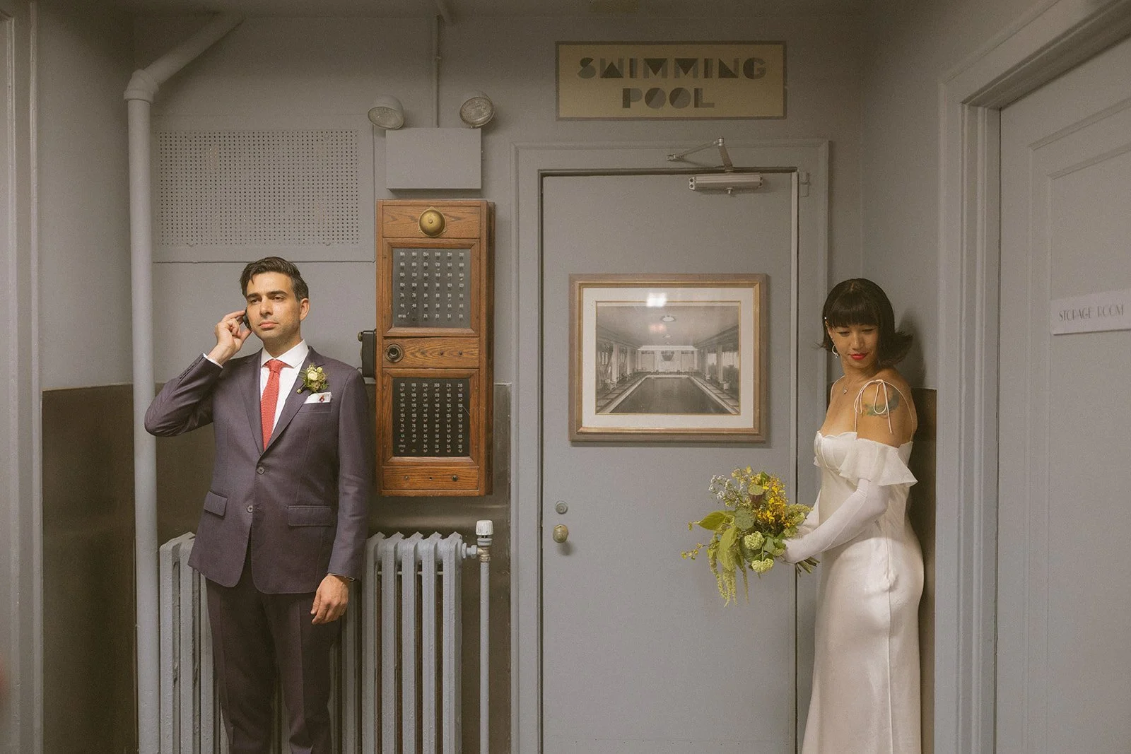 Quirky wedding portrait by Swimming Pool sign showcasing Wes Anderson cinematic composition style