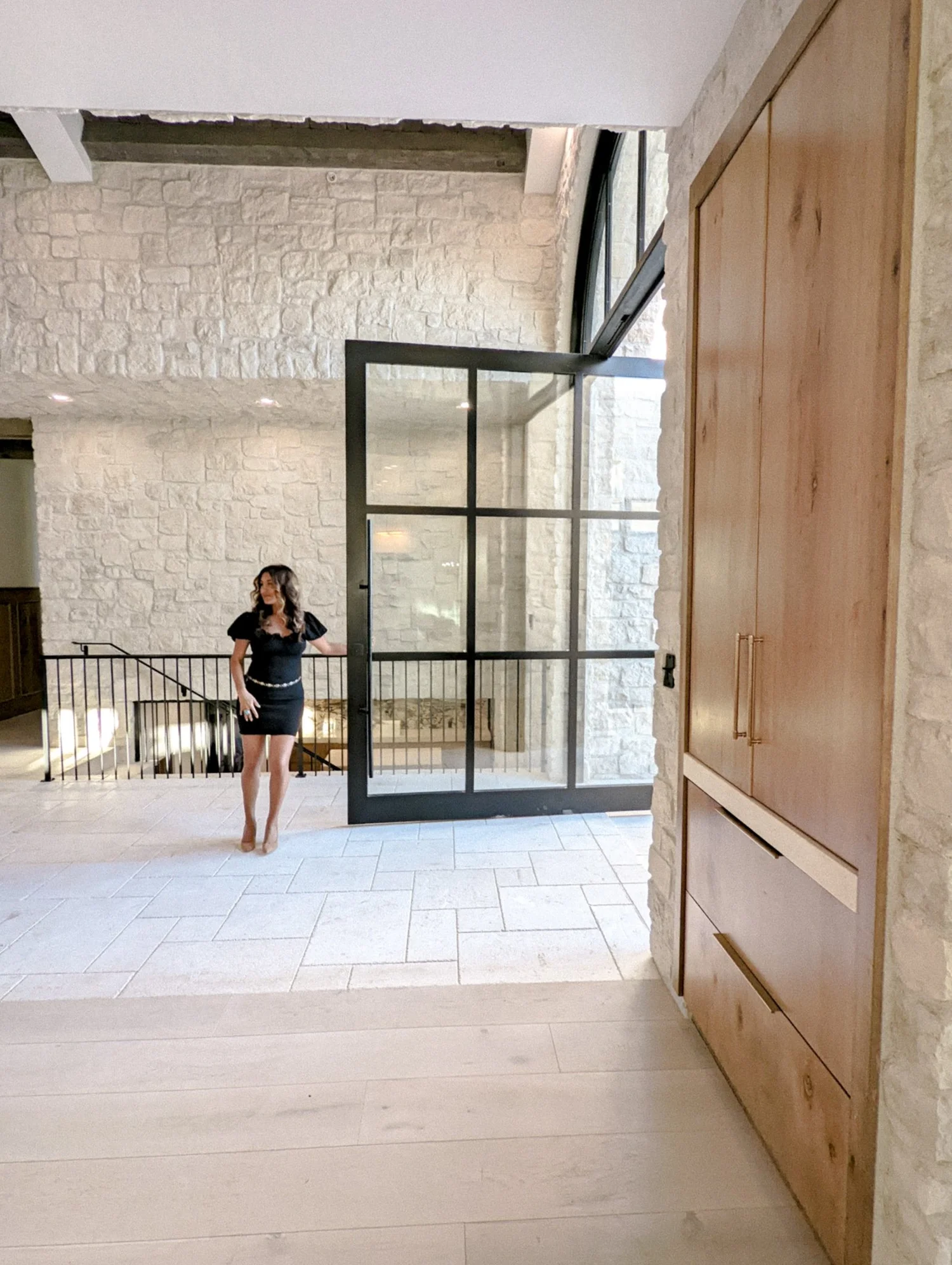 Shirley Slee beside an open glass door in a light-filled interior