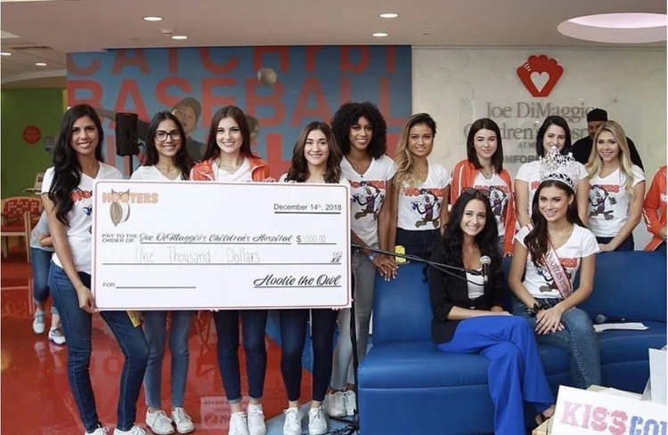 Victoria Ruiz and fellow Hooters Girls at a charity check presentation
