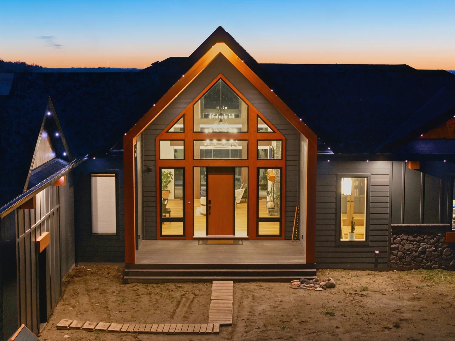 Gabled home with illuminated windows at dusk