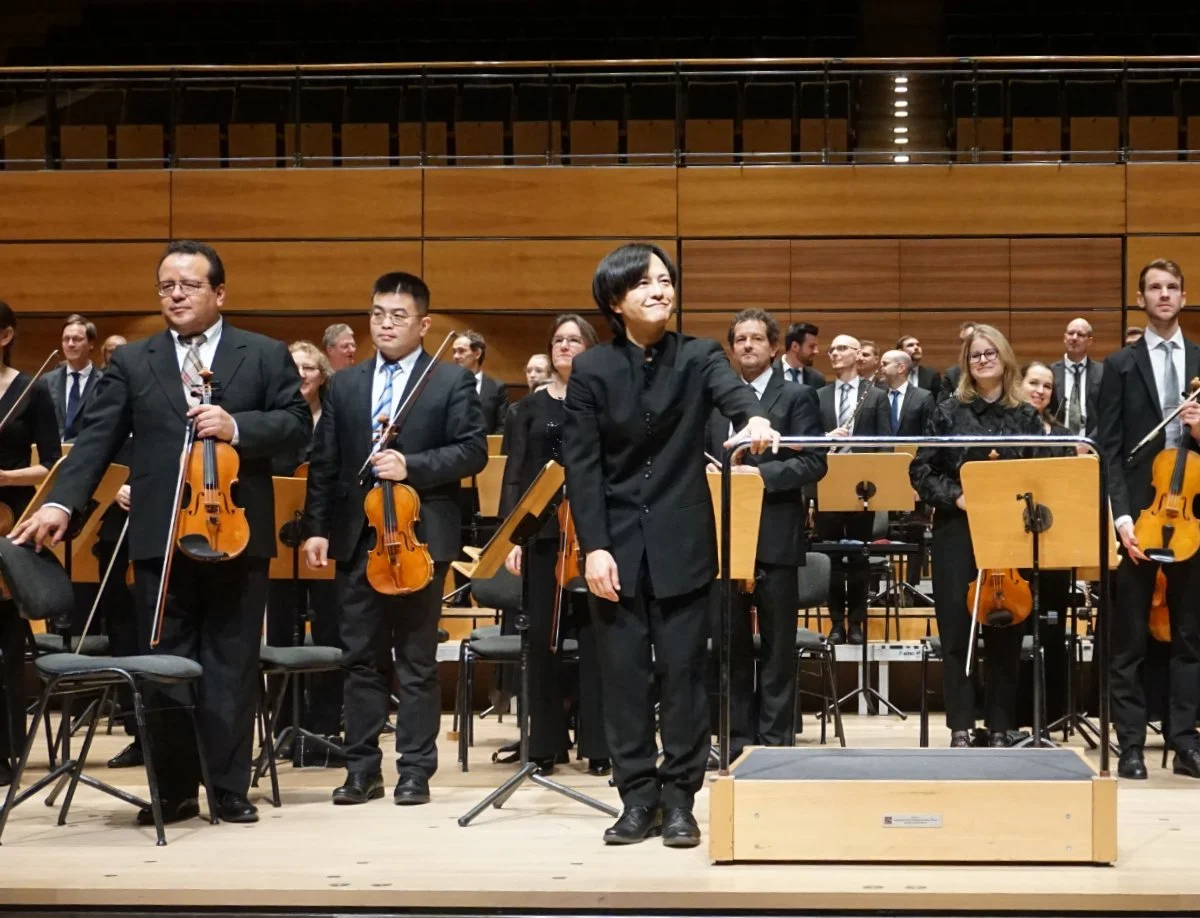 Takahiro Nagasaki and the Philharmonisches Orchester der Hansestadt Lübeck taking applause at the MuK, 24 November 2024.