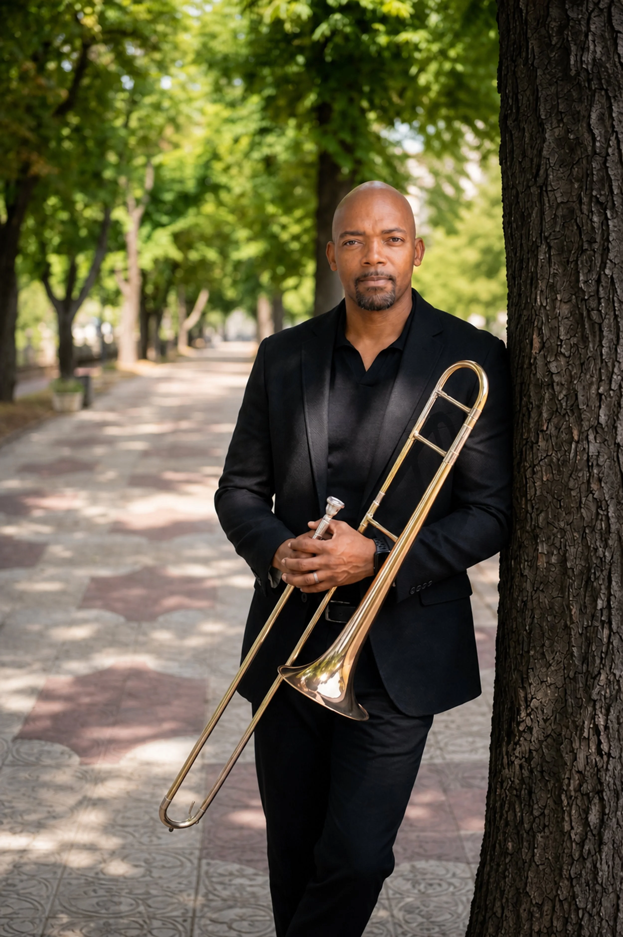 Clarence Hines standing outdoors with a trombone