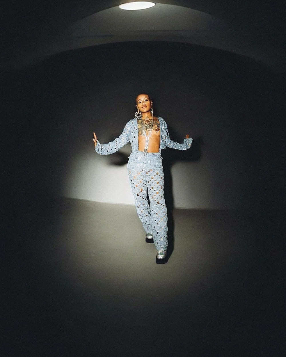 Full-length editorial portrait in a pool of light