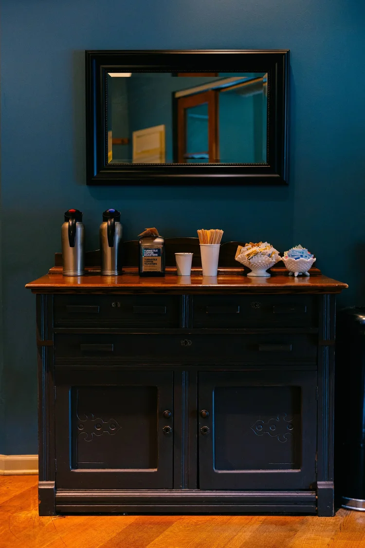 The condiment station against a deep teal wall