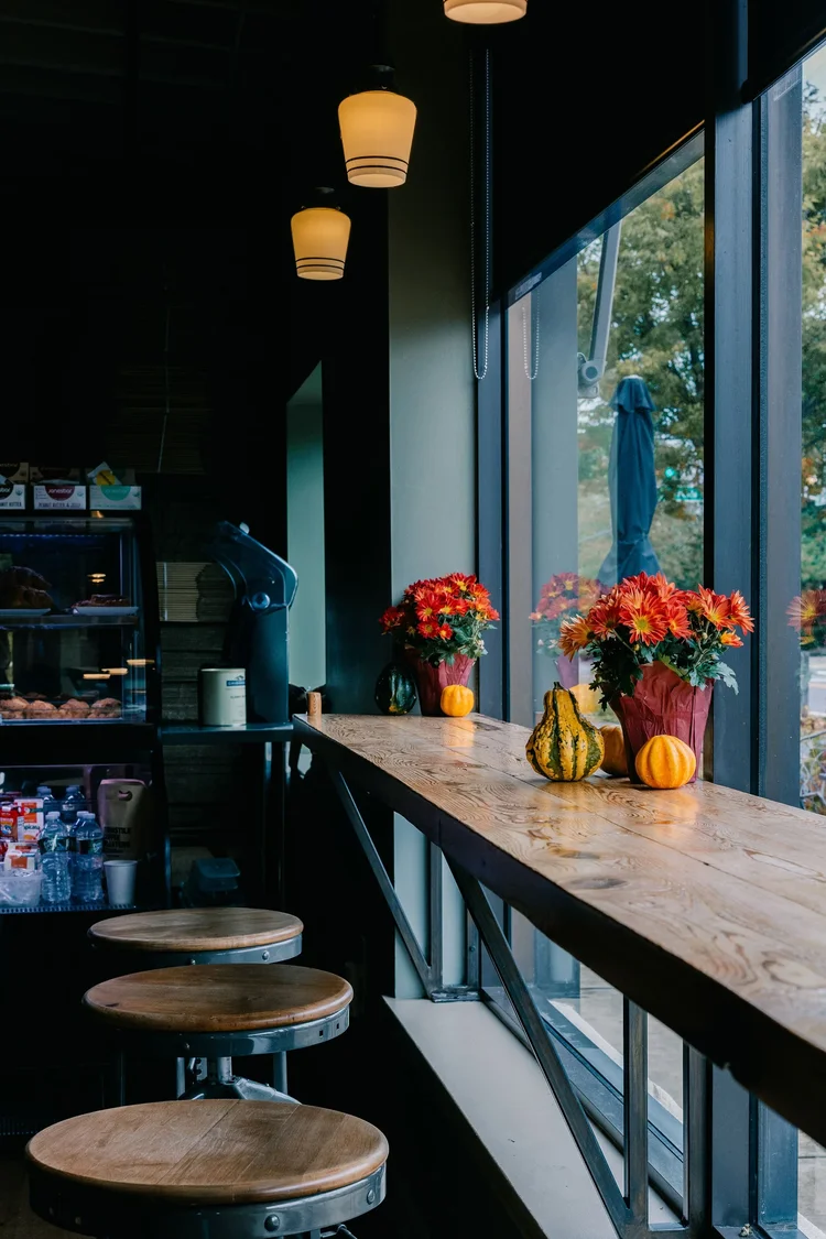 Window bar seating with stools and autumn flowers