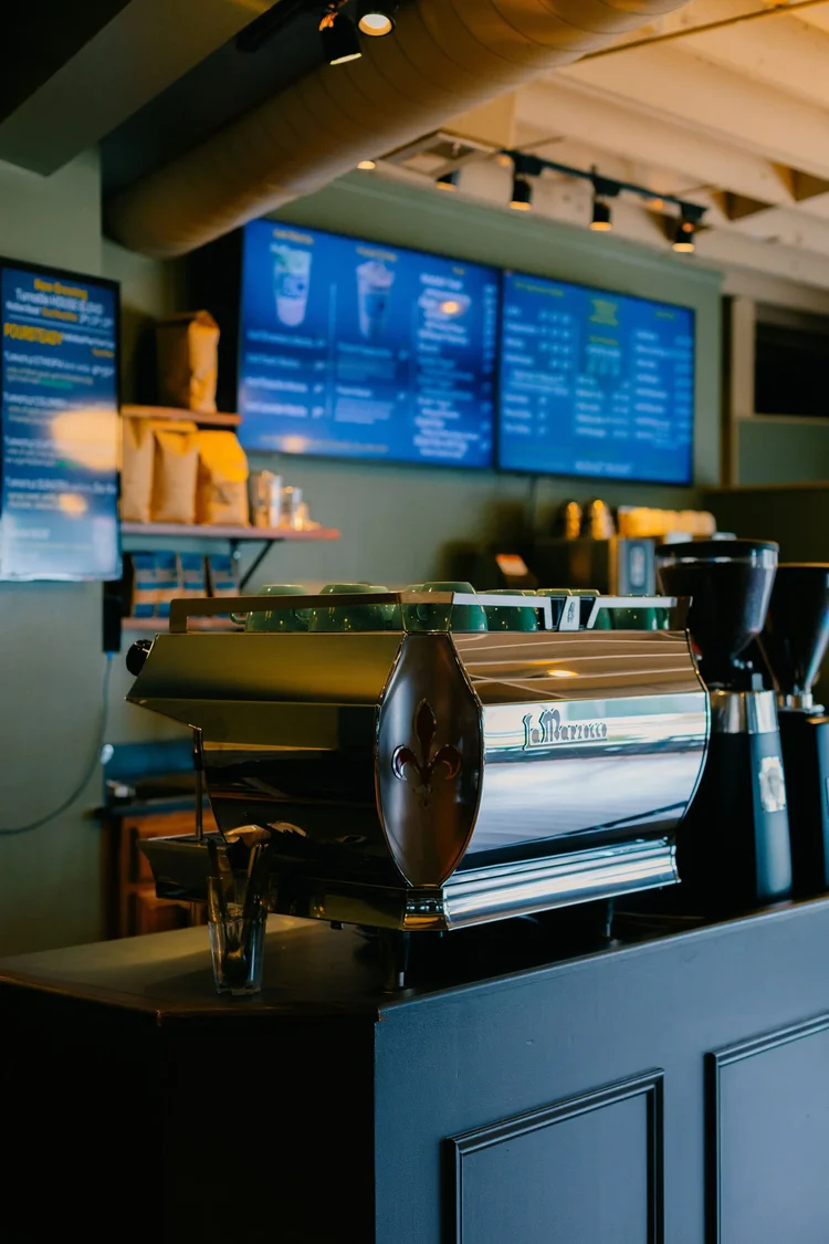 The espresso machine and menu boards behind the counter