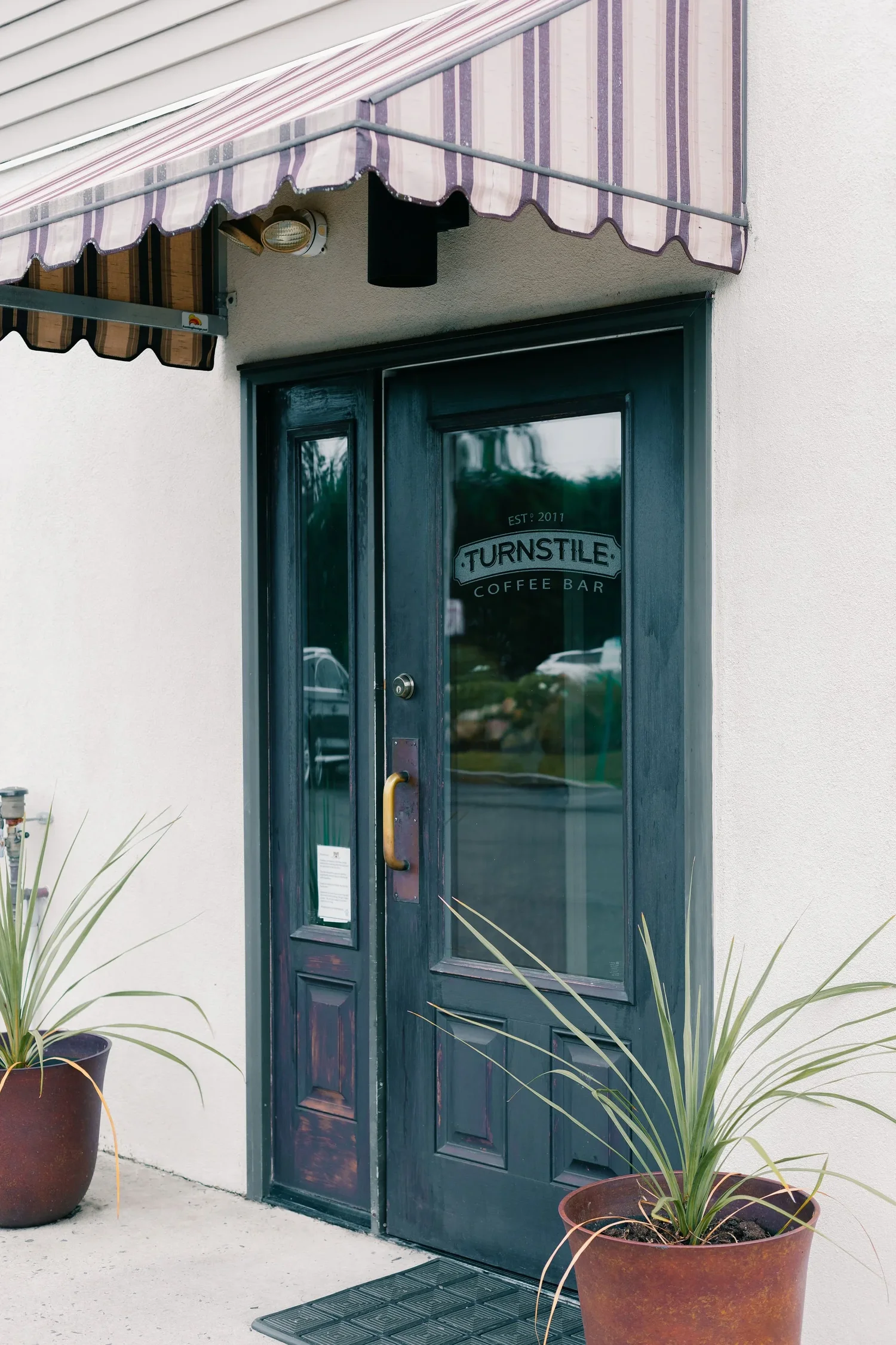 The Turnstile Coffee Bar storefront door with striped awning