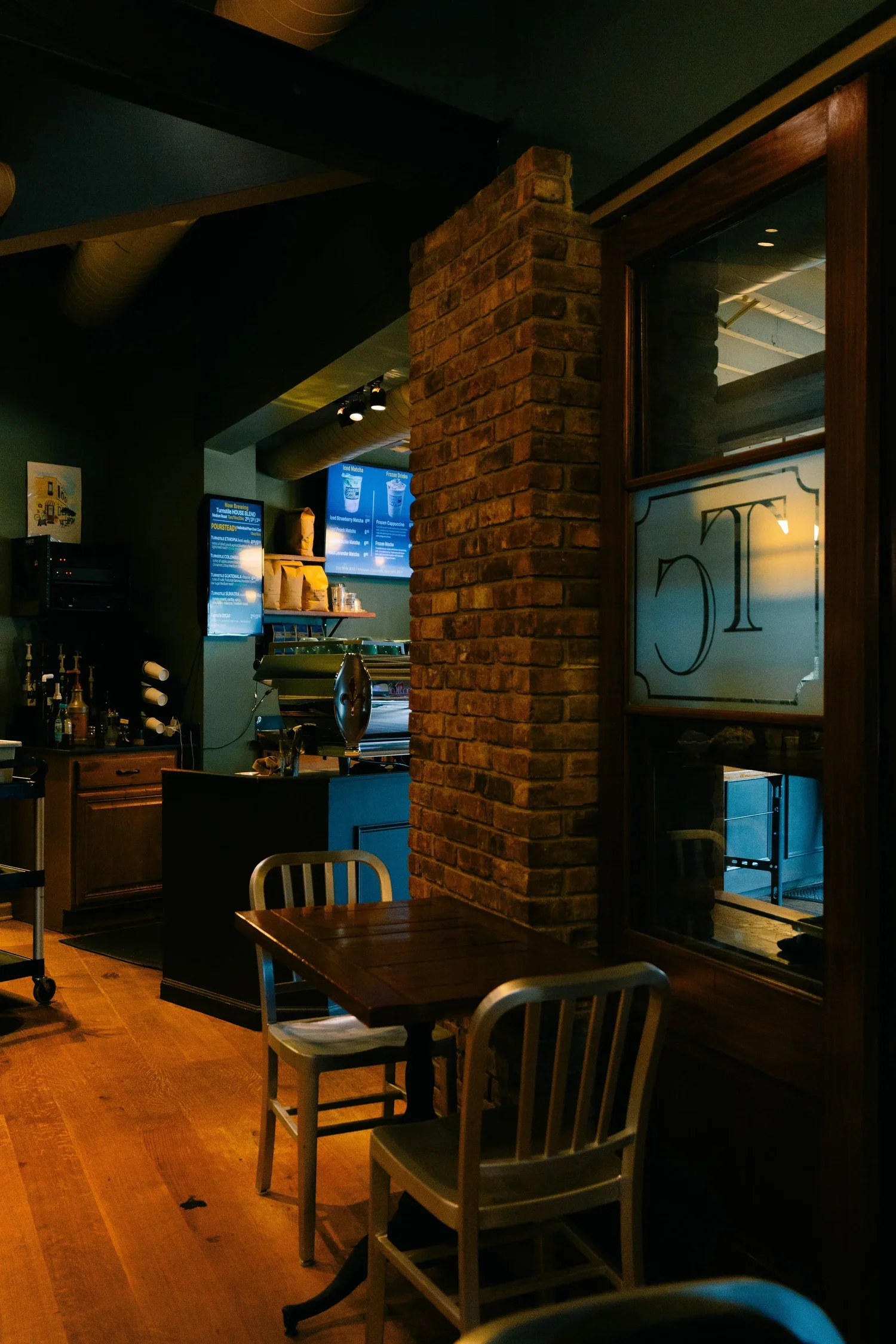Exposed brick column and the etched glass Turnstile partition
