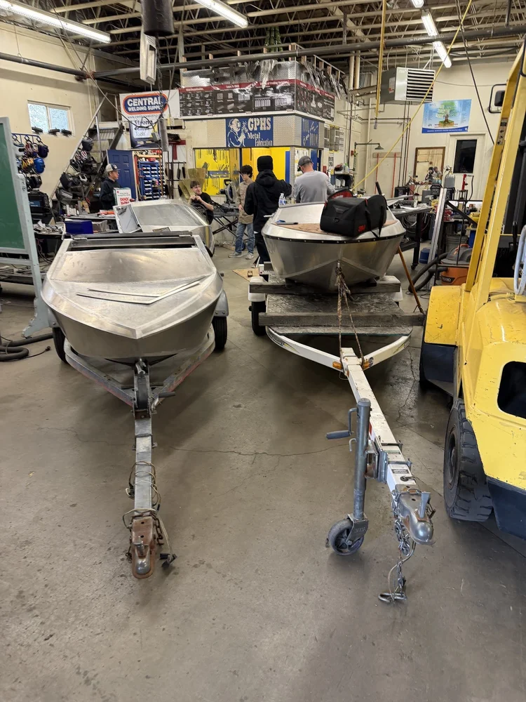 Assembled aluminum boats supported on stands in the workshop