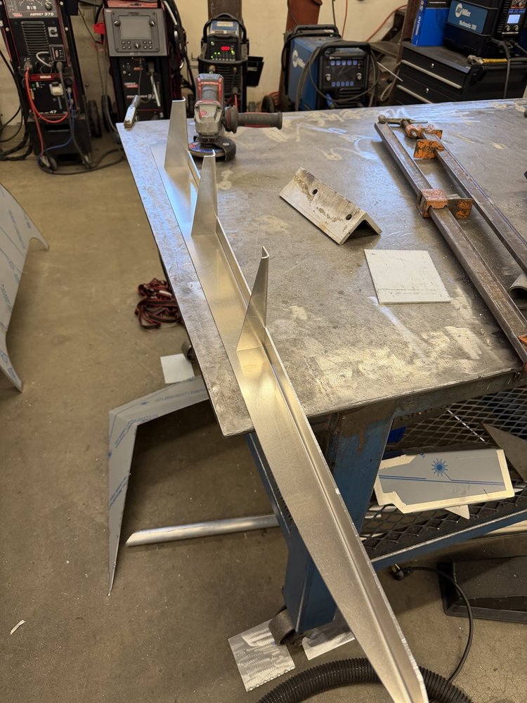 Long aluminum stringer assembly laid out on a workbench