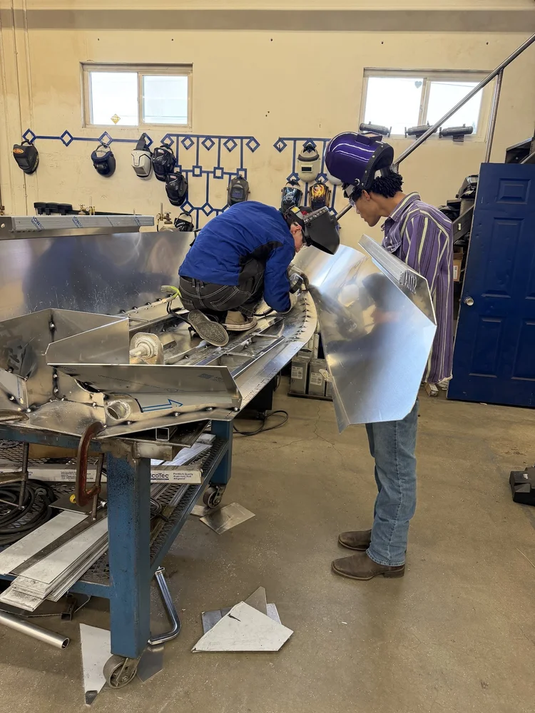 Builders positioning a side panel against the hull