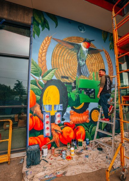 Muralist Francisco Ramirez in front of his new painting. Photo credit: Miguel Ozuna.