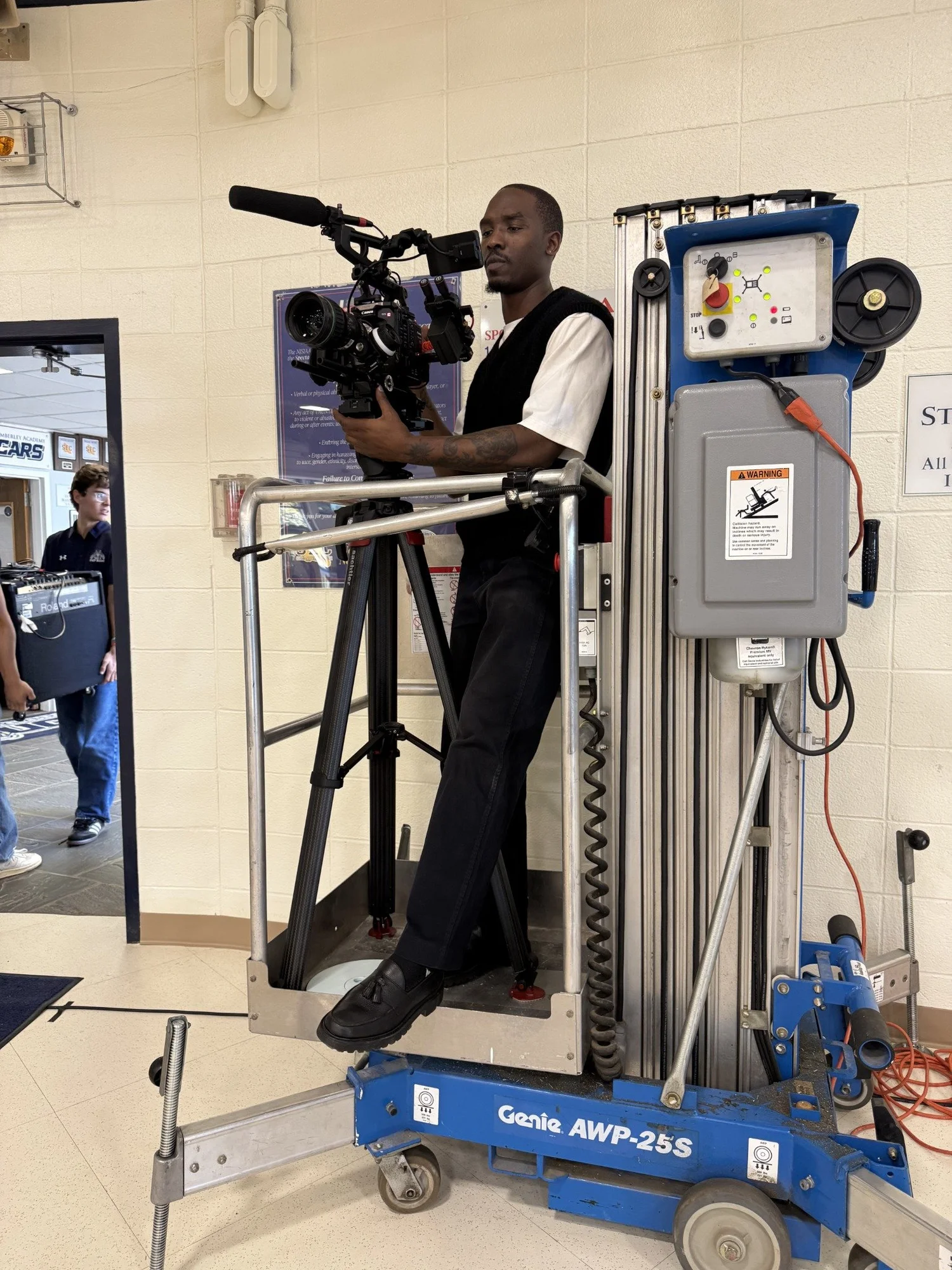 Royce Paris operating a cinema camera from a lift