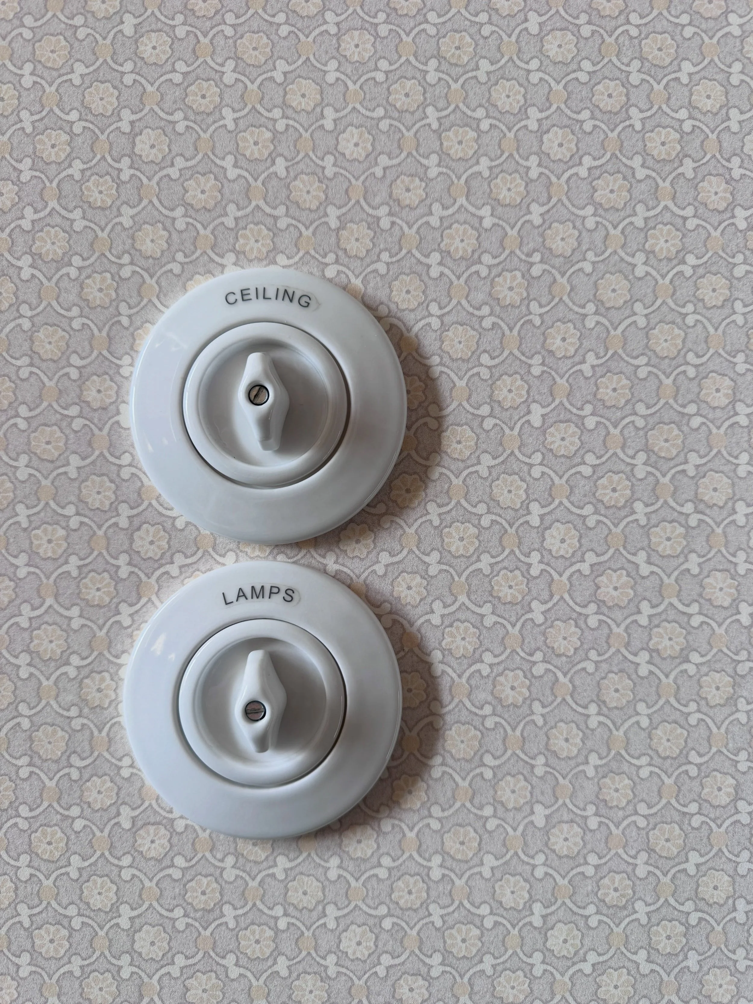 Decorative wall plate with two round vintage-style rotary switches at Soho House Berlin.