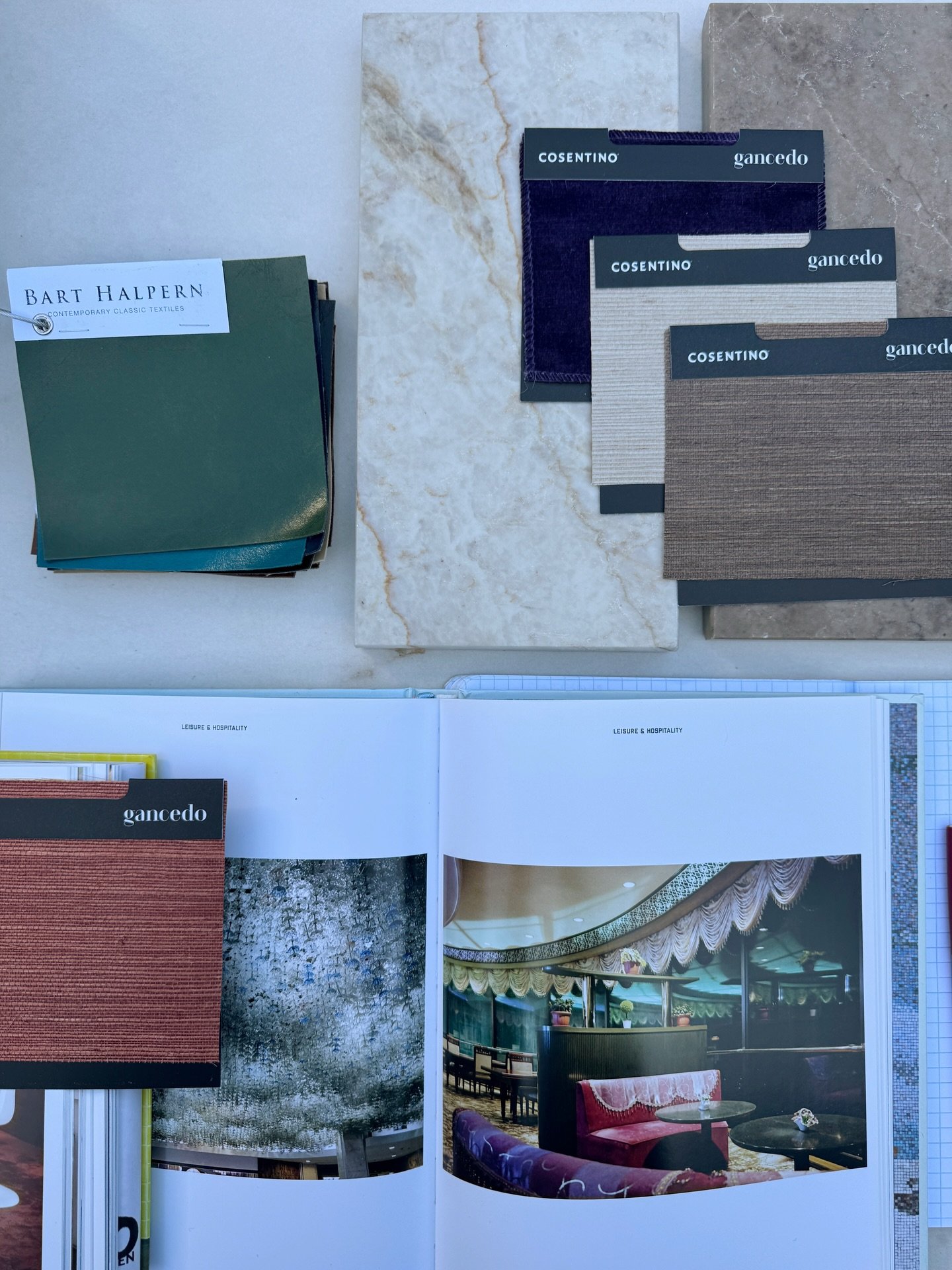 Material samples and design references arranged on a pale stone surface at Cosentino.