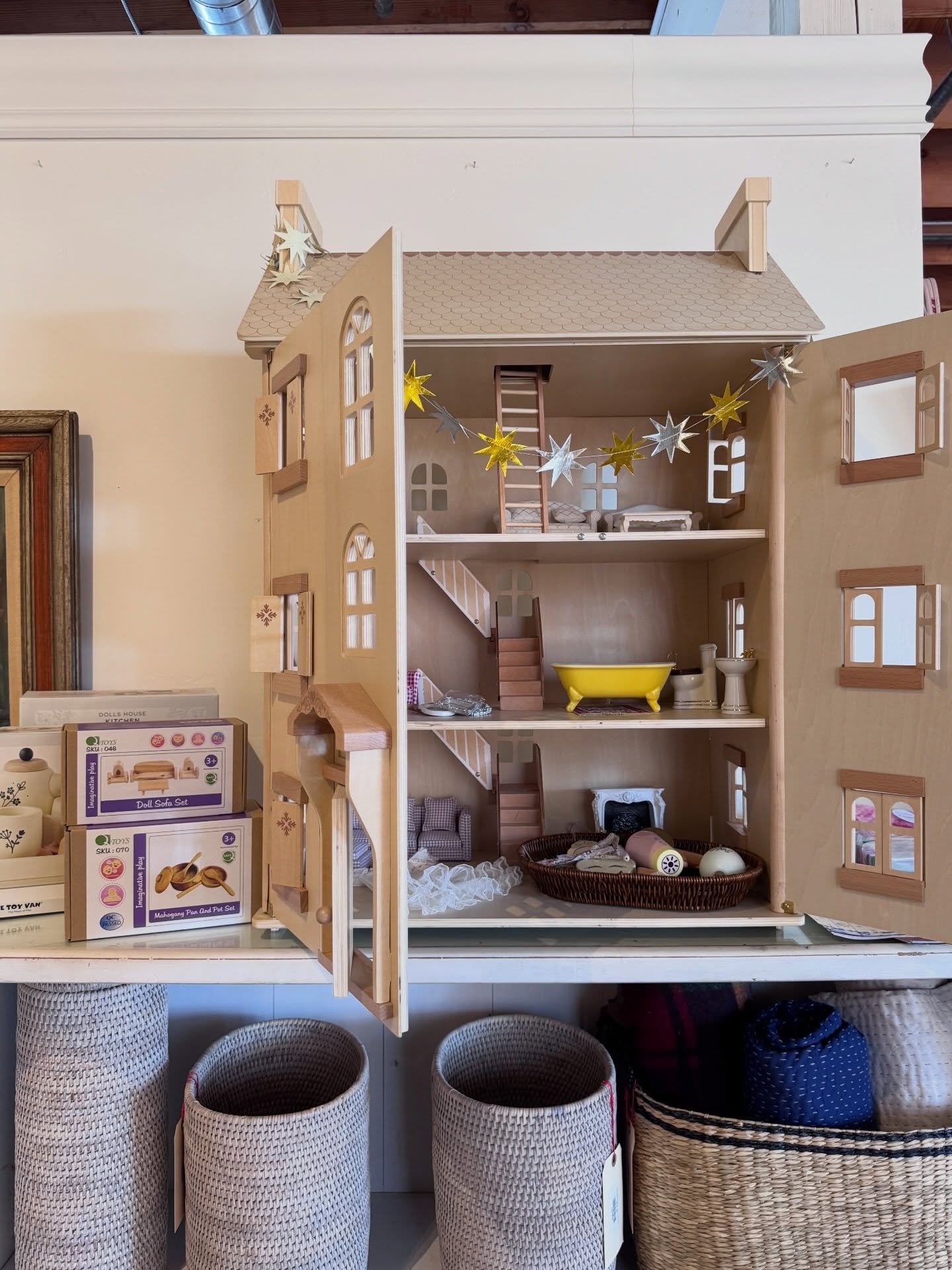 Wood shelves with ceramics, decorative objects, and woven stools in a Newport Beach shop.