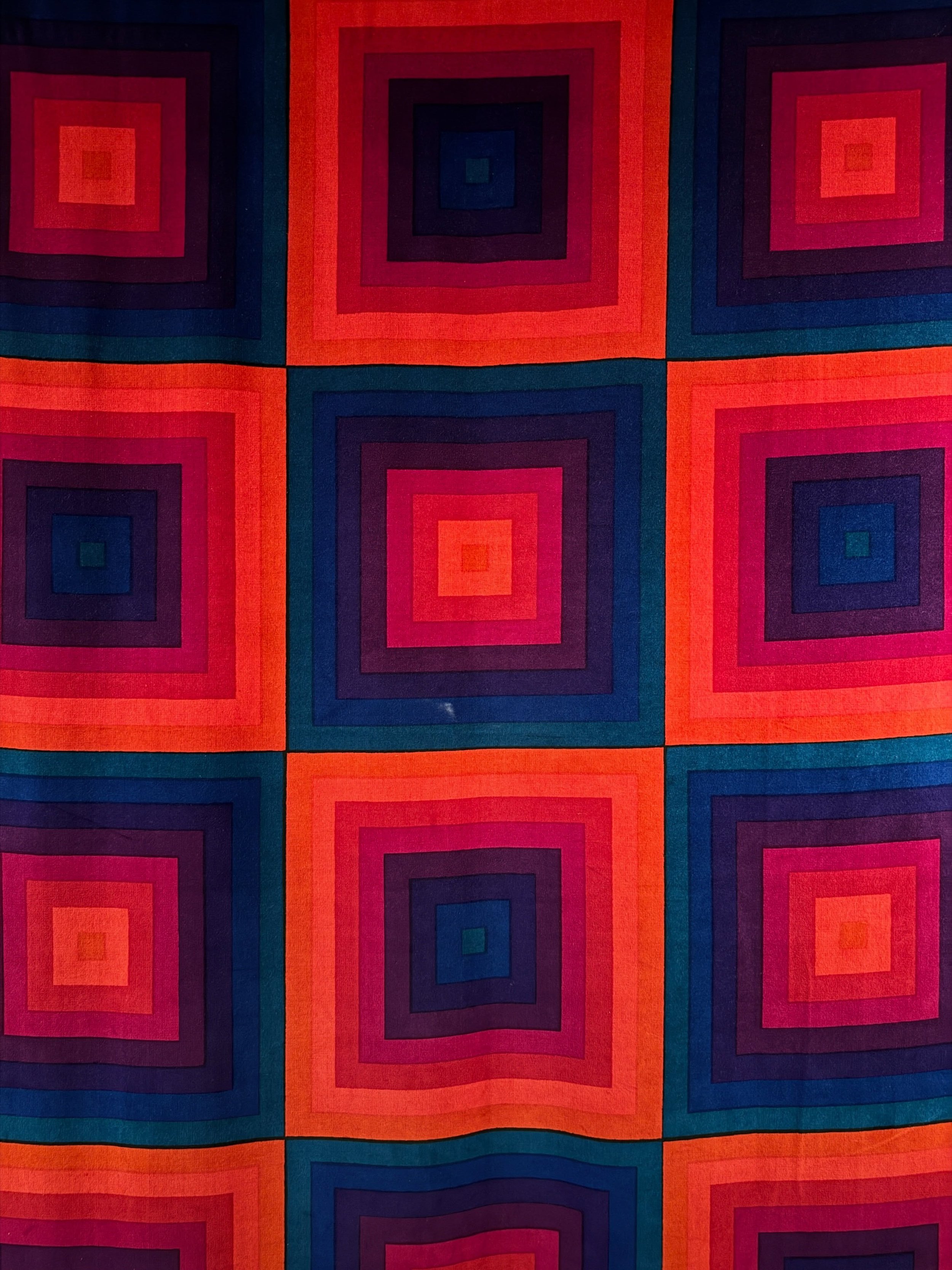 Red, orange, pink, and blue geometric textile at Designmuseum Danmark.