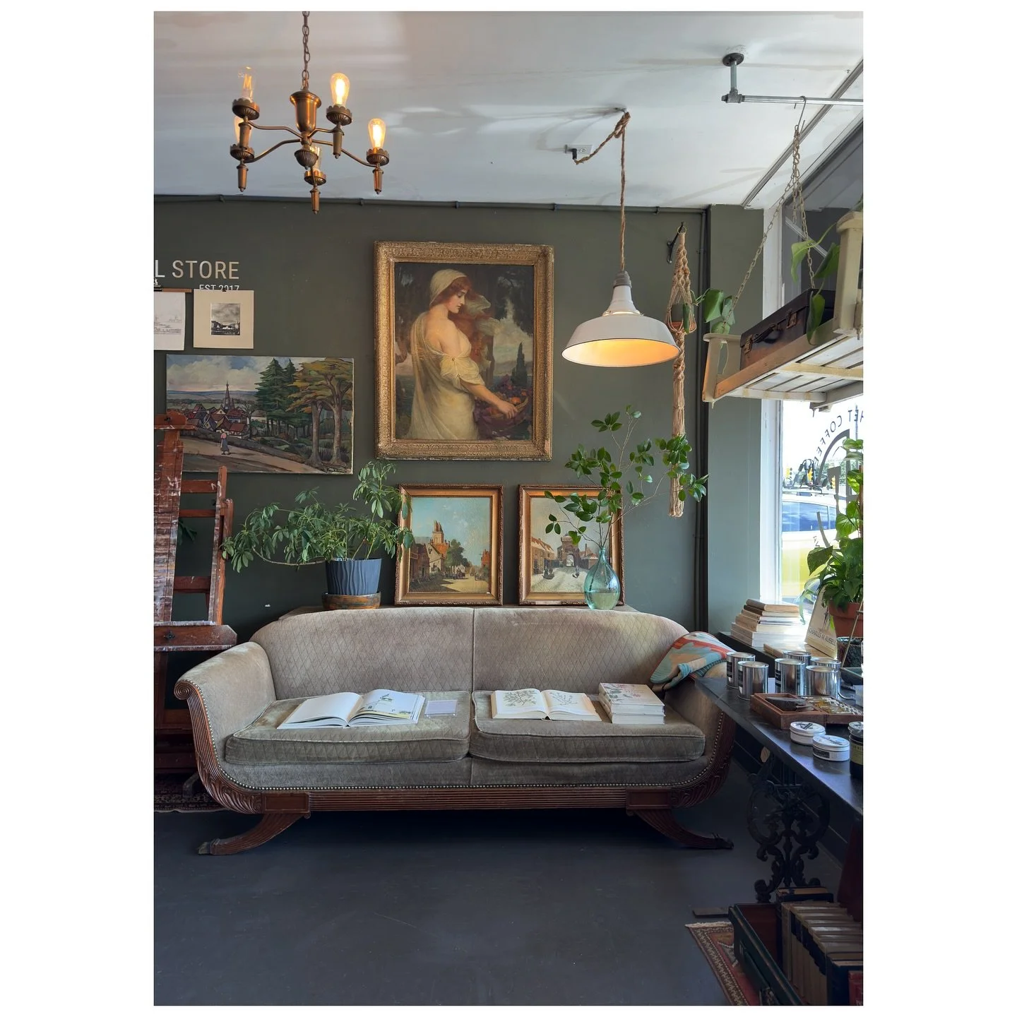 Leclair’s General Store interior with a gray sofa, gallery wall, wood furniture, and hanging lights.