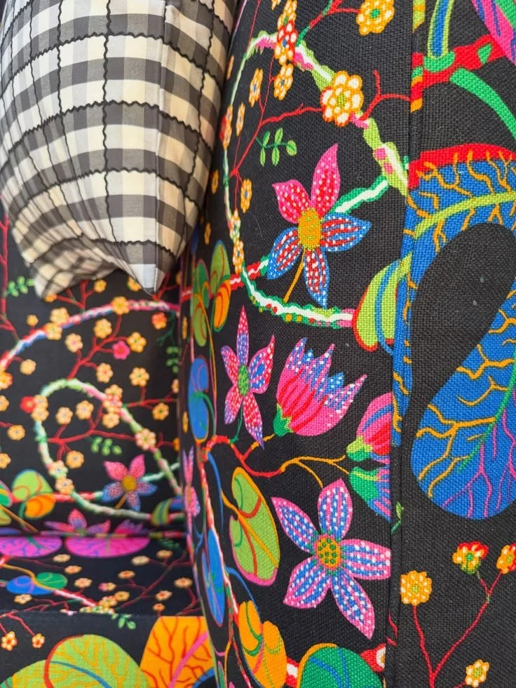 Fabric rolls combining black-and-white gingham with colorful botanical prints at Svenskt Tenn.