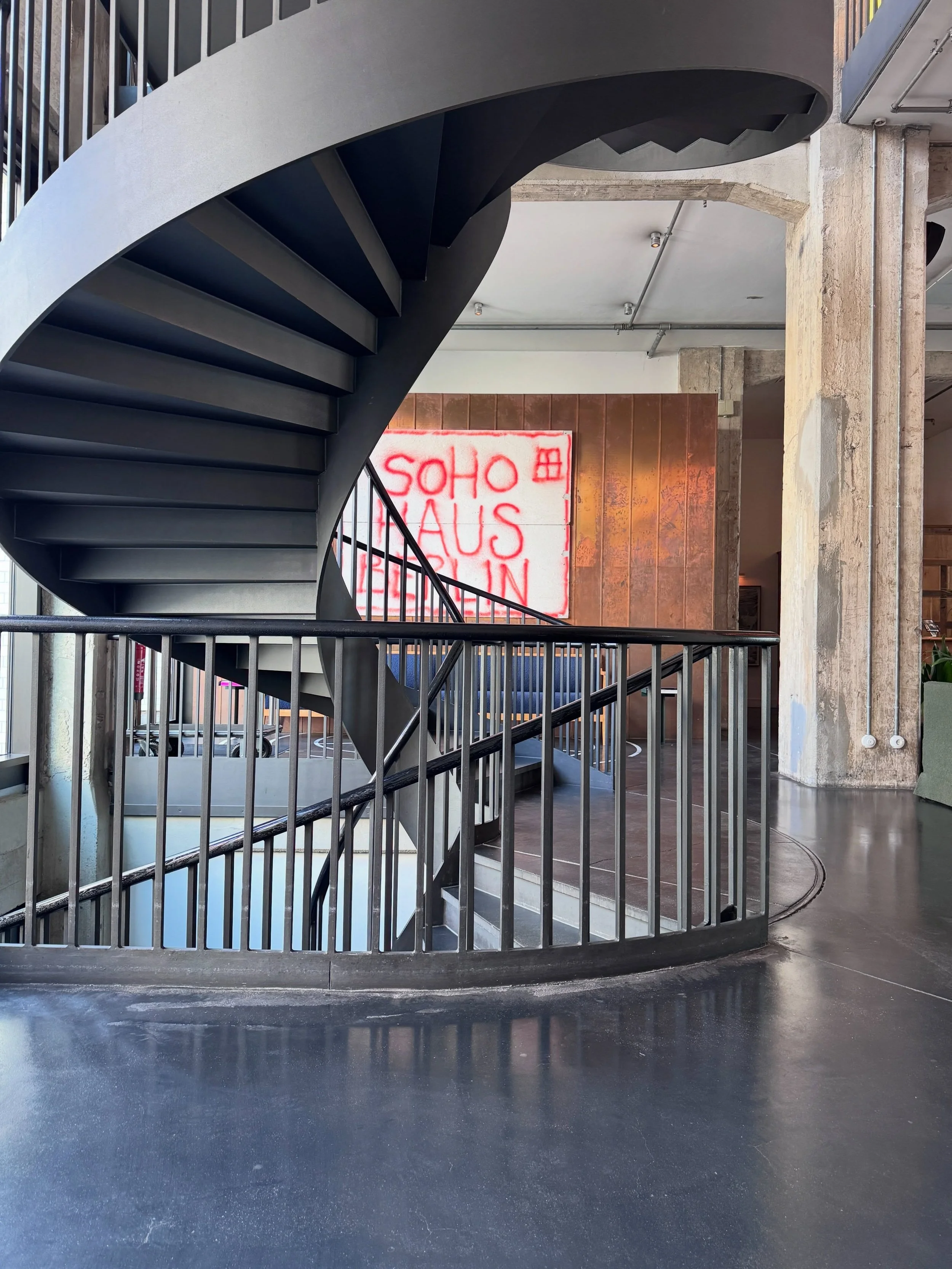 Black spiral staircase and curved railings at Soho House Berlin.