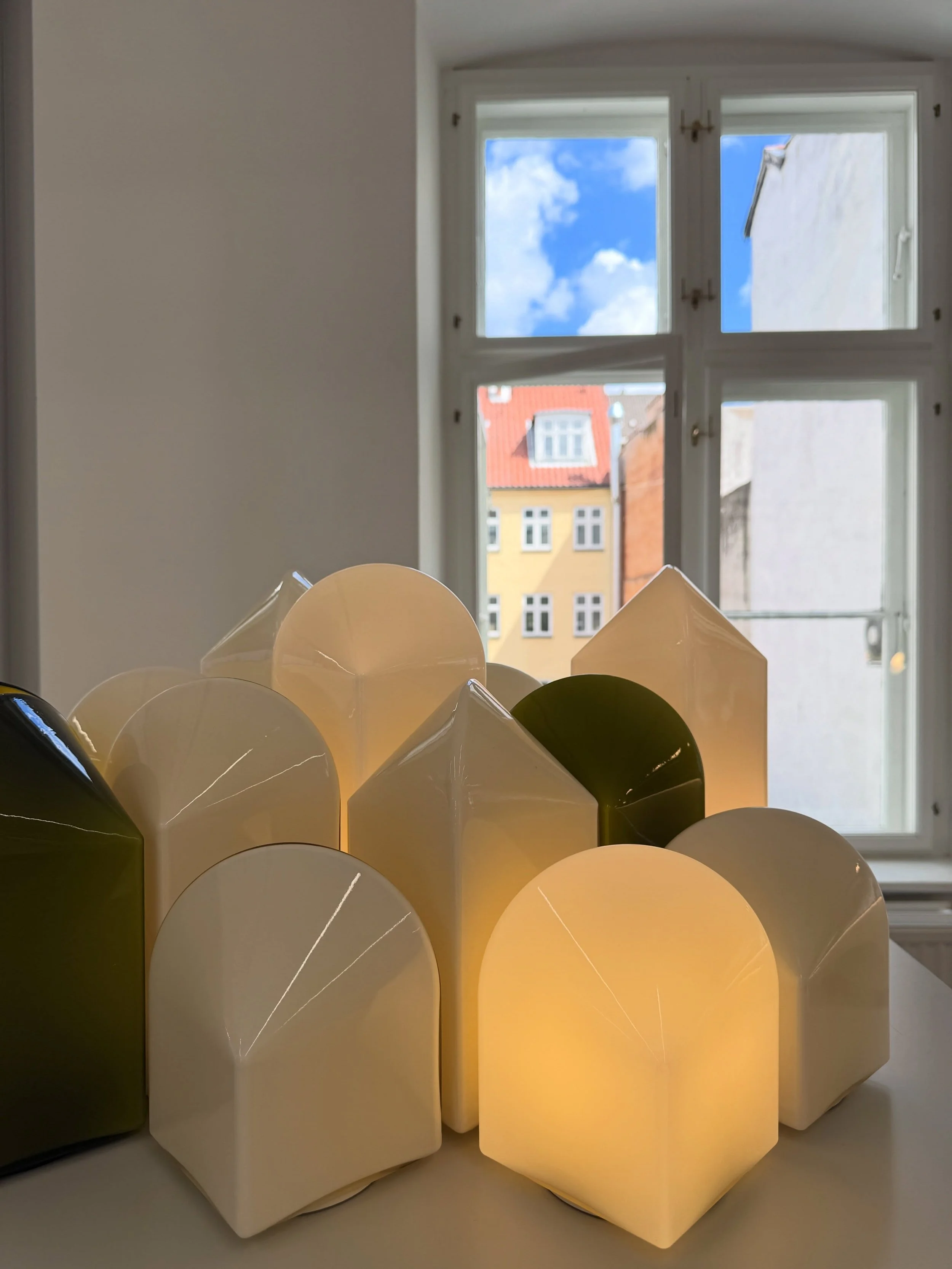 Sculptural pale-yellow lighting shades displayed beside Copenhagen showroom windows.