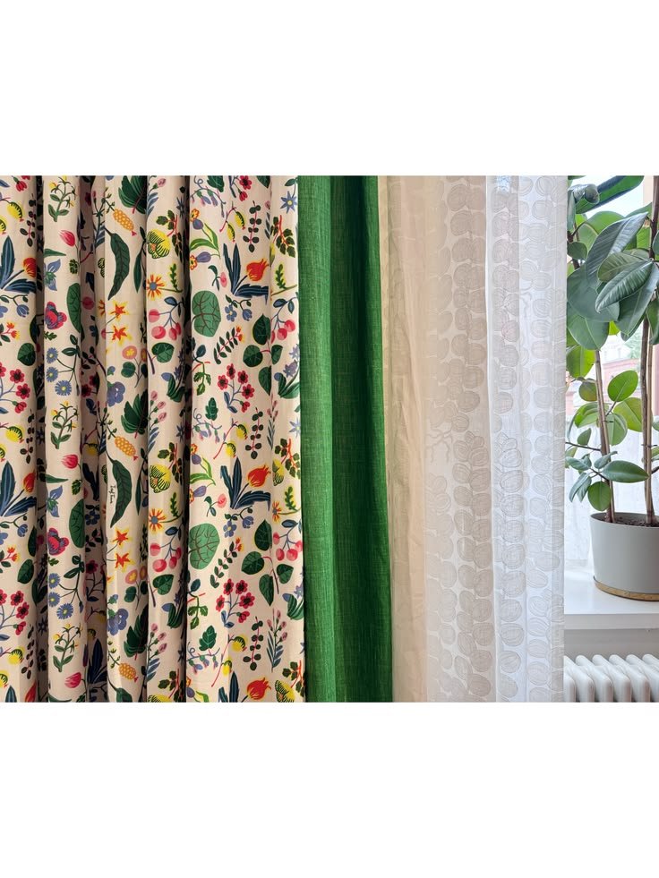 Colorful printed curtains with solid green and yellow panels beside a window at Svenskt Tenn.