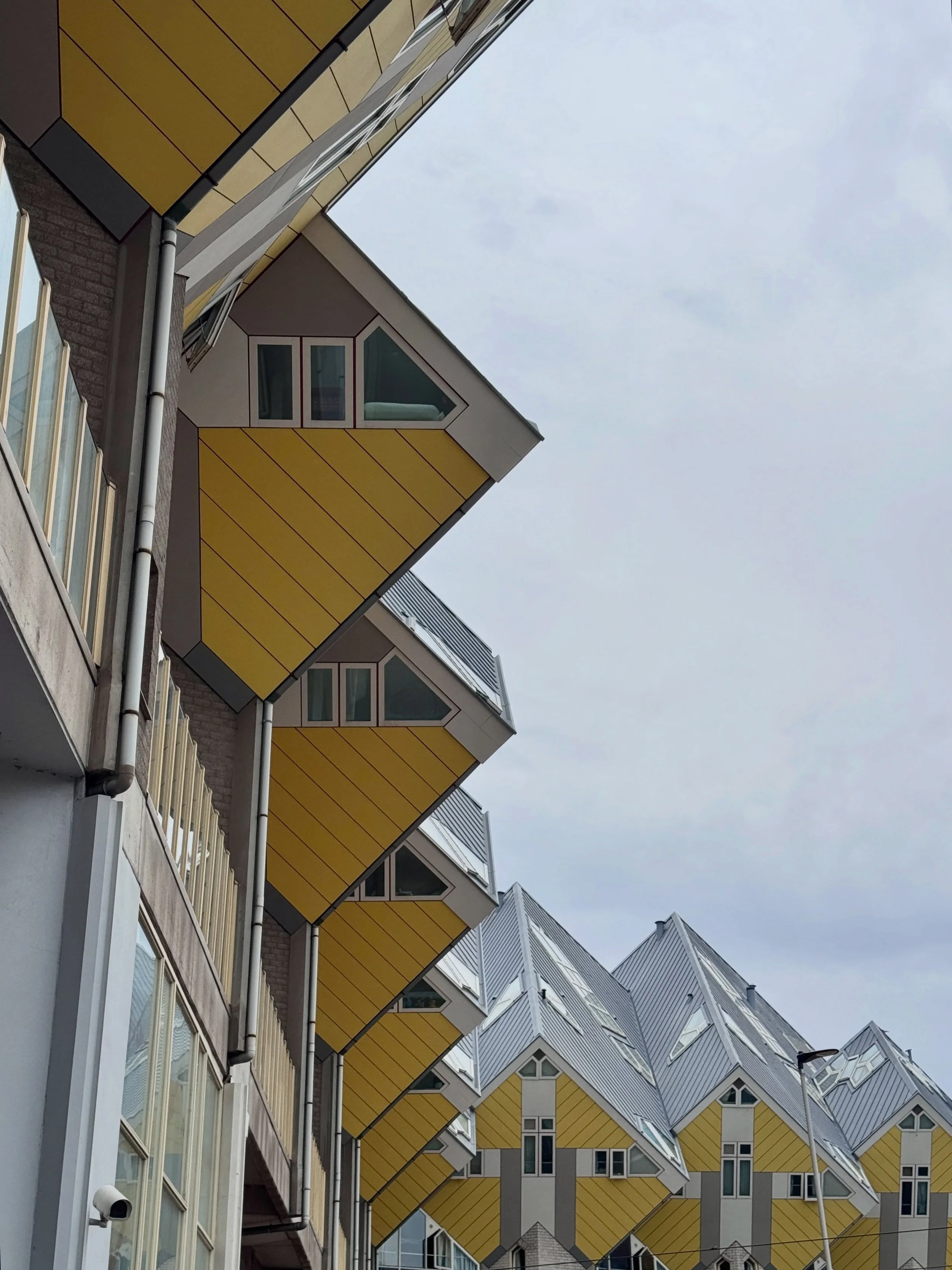 Yellow Cube Houses in Rotterdam, with tilted windows and angular roofs.