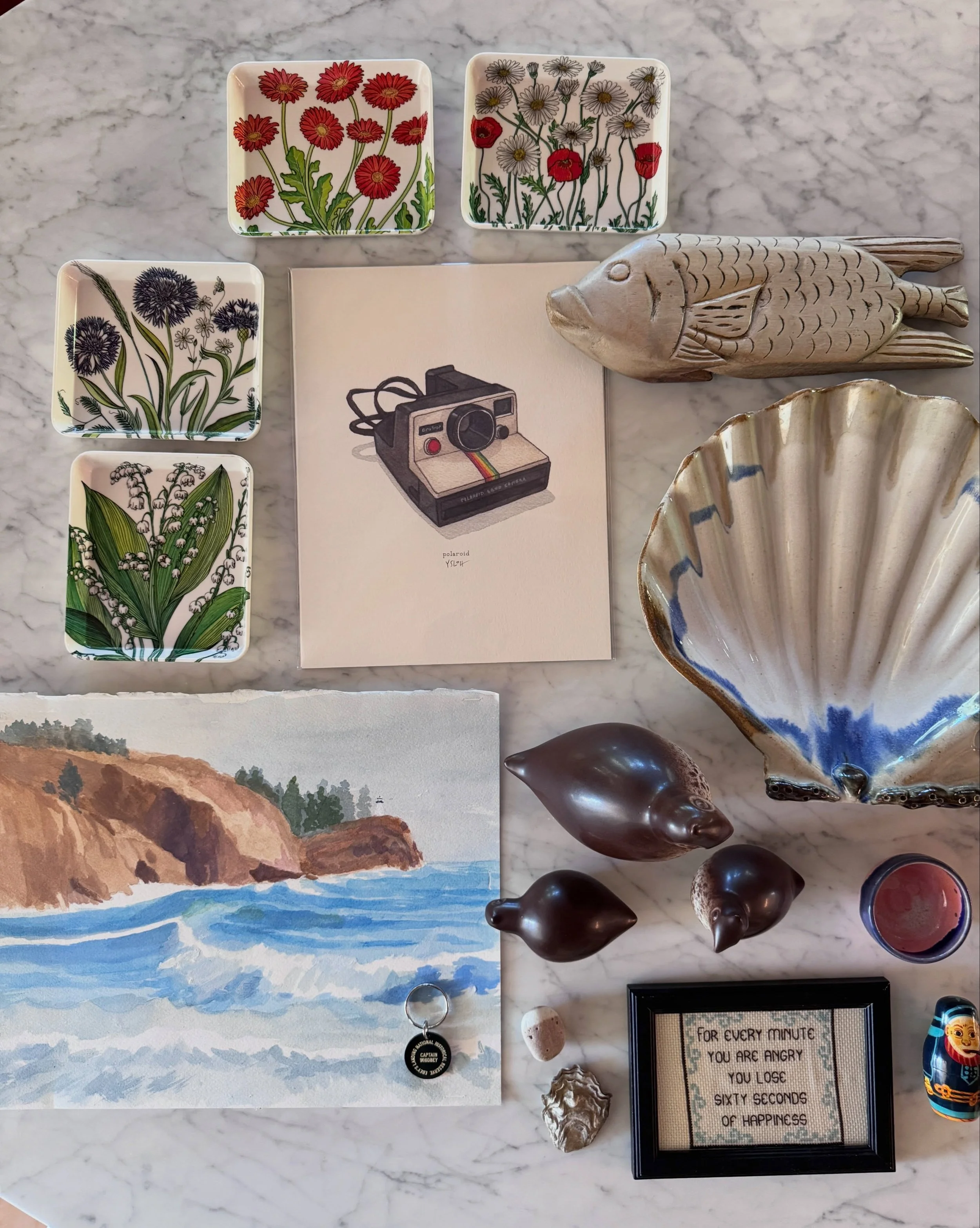 Collected objects including floral textile samples, shells, small art, and colored stones.