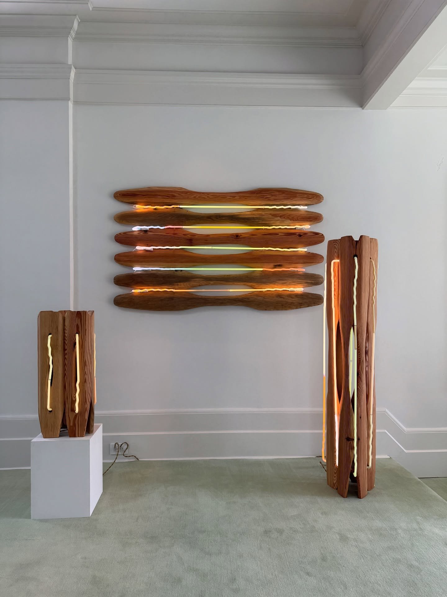 Sculptural amber-colored objects displayed in a pale gallery interior.