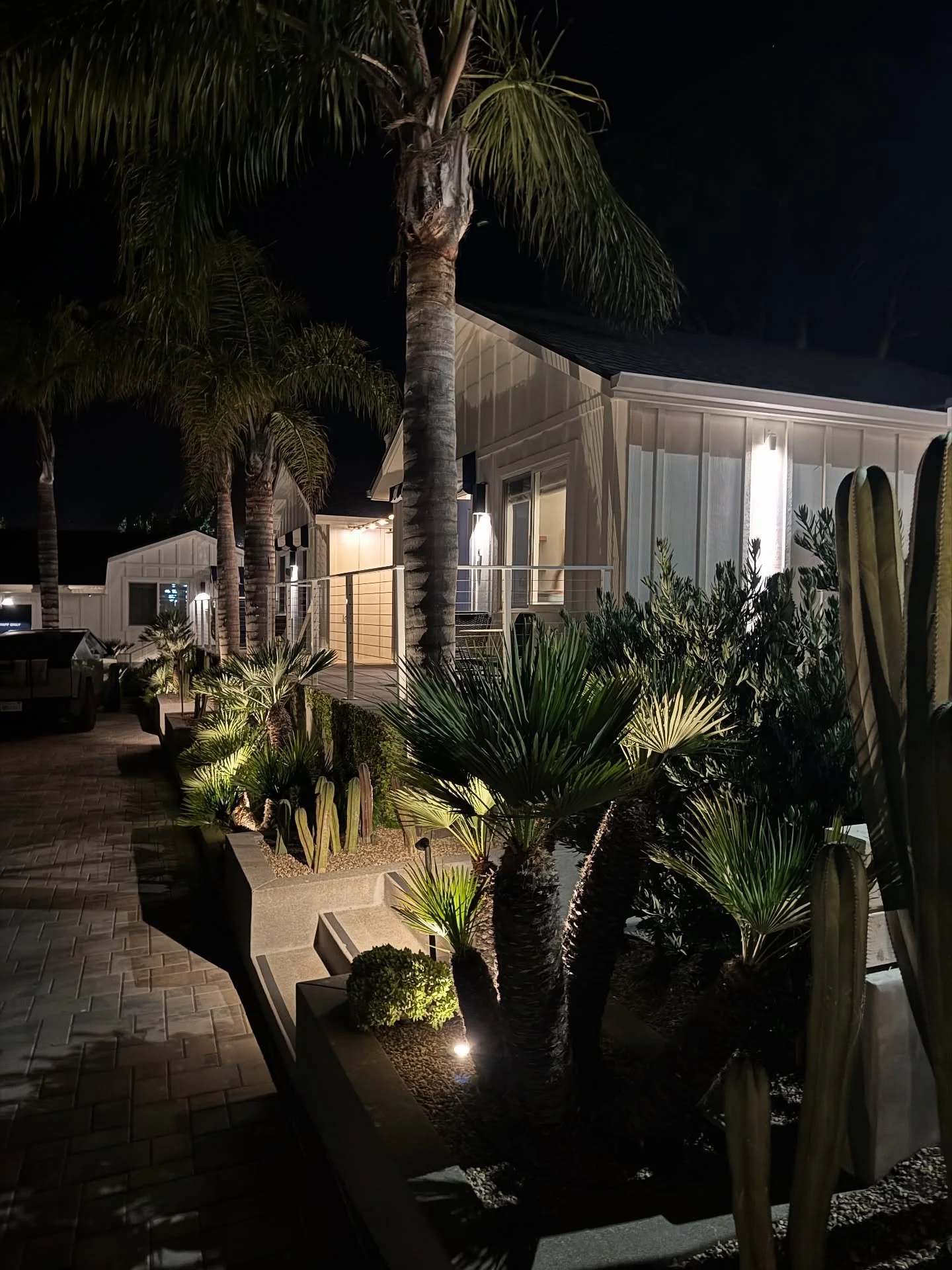 Outdoor seating, palms, and planted borders at The Pacific Motel in Cayucos.